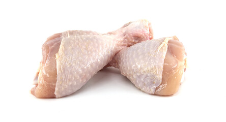 Two raw chicken drumsticks lying on a white background