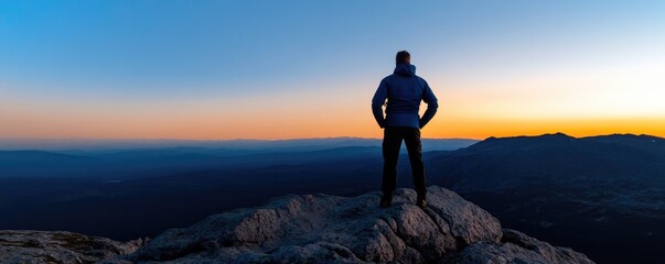 Man Contemplating Sunrise from Mountain Peak