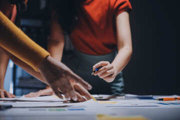 Business people working late at laptop in highrise office
