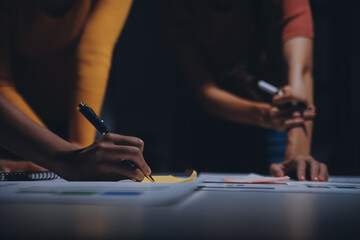 Business people working late at laptop in highrise office