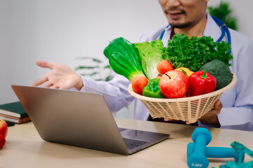 A male nutritionist sitting at a table, advising on healthy diets, promoting vegetable-based meals,...