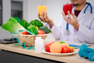 A male nutritionist sitting at a table, advising on healthy diets, promoting vegetable-based meals,...