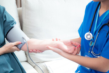 Caregiver caucasian young nurse woman measuring blood pressure with patient for checkup pulse...