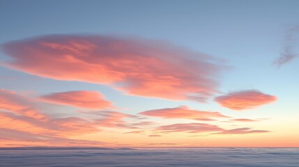 Fototapeta premium Pink and orange clouds at sunset over a sea of clouds.
