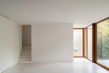 Modern minimalist interior with natural light in residential space overlooking greenery