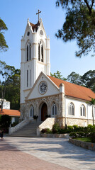 Hillside church, red roof, stone facade, tranquil setting, travel photography