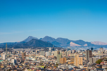 大分市市街地と遠くに見える鶴見岳と由布岳の風景