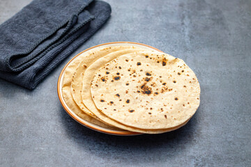 Roti is a traditional, round, unleavened flatbread made from whole wheat flour, commonly served with curries or vegetables.