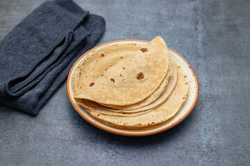Roti is a traditional, round, unleavened flatbread made from whole wheat flour, commonly served with curries or vegetables.