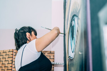 Modern Female Painter Working Passionately On A Large Contemporary Artwork In A Professional...