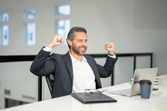 Middle aged businessman working with laptop in office. Excited business man using laptop. Millennial man using laptop at office workplace. Ceo manager office worker business people working at office.