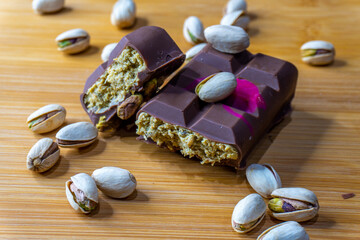 Dubai Chocolate bar with green kadayif and pistachio spread with pistachio nuts close up