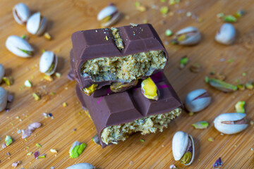 Dubai Chocolate bar with green kadayif and pistachio spread with pistachio nuts close up