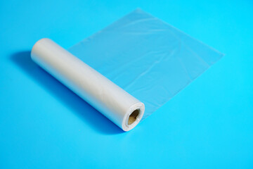 Roll of transparent packaging bags on a blue background. storage and packaging of products at home.