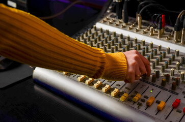 Hand operating audio mixer in music recording studio