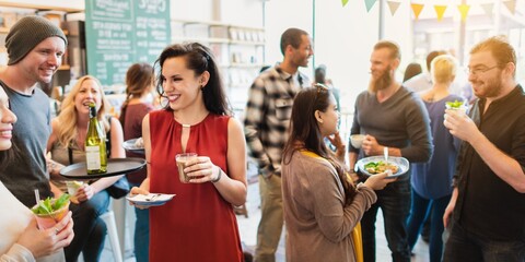 Diverse group socializing at a casual gathering. Men and women enjoying drinks and food. Lively...