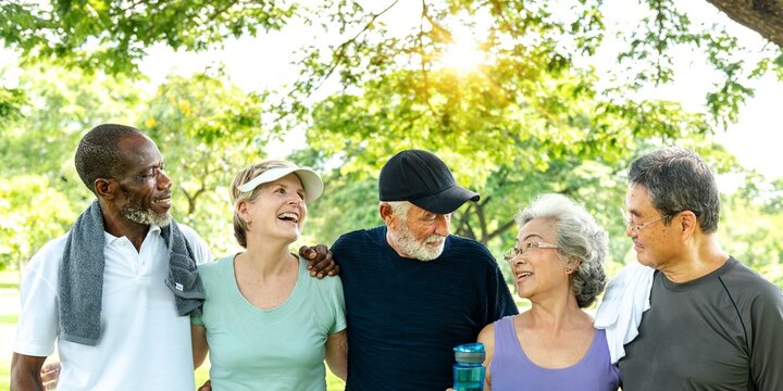 Diverse group of elderly friends enjoying exercise outdoors. Elderly friends, diverse group exercise in park. Diverse elderly friends exercise together. Happy elderly friends in park, healthy exercise