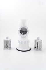 Mechanical grater on a white background. Multislicer grater for vegetables and fruits 3 in 1 with attachments. 