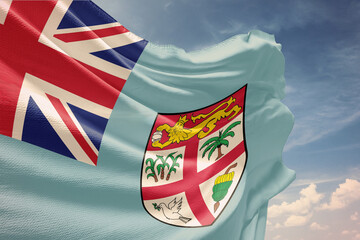 Waving flag of Fiji in blue sky. Fiji flag on pole for Independence Day. The symbol of the state on wavy fabric.