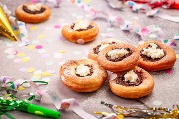 Carnival powdered sugar raised donuts with jelly and cream cheese, paper streamers and confetti