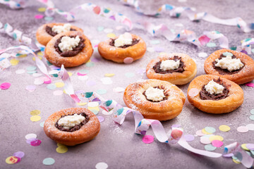 Carnival powdered sugar raised donuts with jelly and cream cheese, paper streamers and confetti