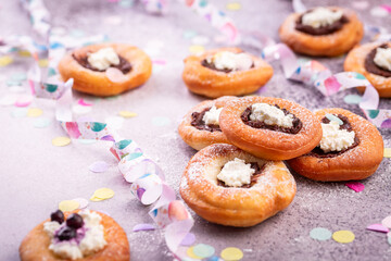 Carnival powdered sugar raised donuts with jelly and cream cheese, paper streamers and confetti