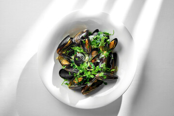 A plate of freshly steamed mussels, served in their shells with a generous portion of aromatic...