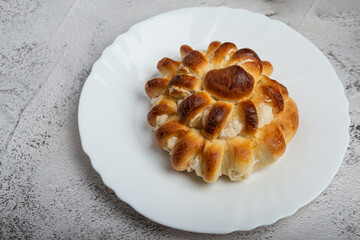 Close-up of a freshly baked stuffed bun on a white plate
