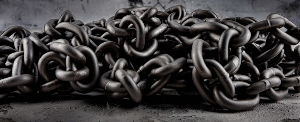 A heavy iron chain. A pile of iron chains.