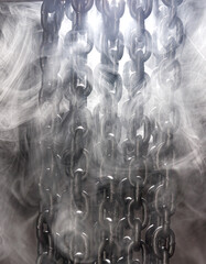 Heavy iron chain. A row of iron chains hanging in the smoke. Smoke around a curtain of chains.