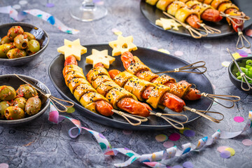 Carnical food, long sausages wrapped in yeast dough, corn dog with mustard and olives