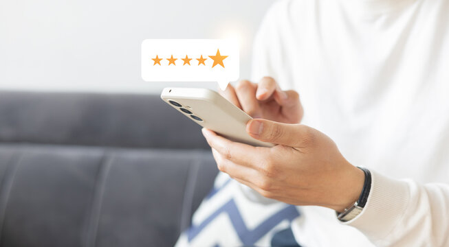 close up man hand use smartphone and press on screen with gold five star rating feedback icon and press level three rank (best) for give score point to review the service business concept