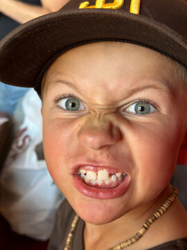 7yo boy shows game face at little league baseball game.
