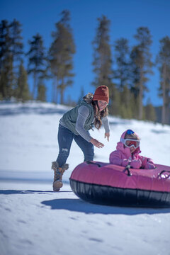 Mom launches 5yo daughter downhill snow tubing.
