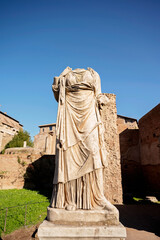 Fototapeta premium Headless ancient Roman marble statue with draped clothing in ruins