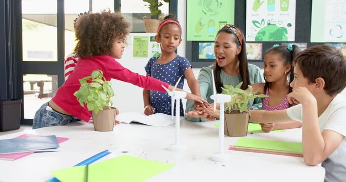 In school, teacher and students discussing plants and renewable energy projects