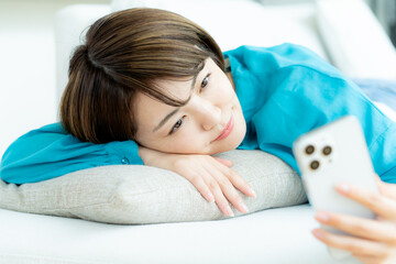 リビングでスマホを操作する女性