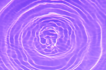 Purple water with ripples on the surface. Defocus blurred transparent pink colored clear calm water surface texture with splashes and bubbles. Water waves with shining pattern texture background.