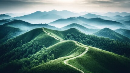 Fototapeta premium Winding road through lush green hills and misty mountains at sunrise.