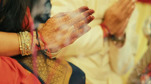 man & Woman worshiping during pooja or ritual celebration at home in India.