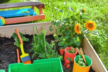 Childrens Garden with Edible Plants: Raised beds filled with strawberries, carrots, and sunflowers. Small gardening tools and a colorful bench are nearby