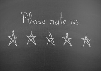 Handwritten message on blackboard asking please rate us with five star drawing