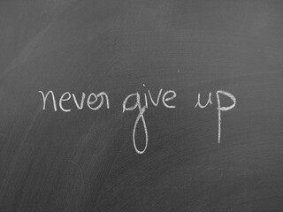 Never give up written on a chalkboard emphasizing perseverance