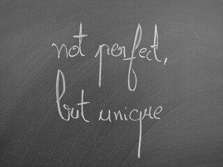Not perfect, but unique quote displayed in chalk on a blackboard