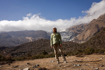 Female stands in valley at base of Manaslu Mountain, Nepal