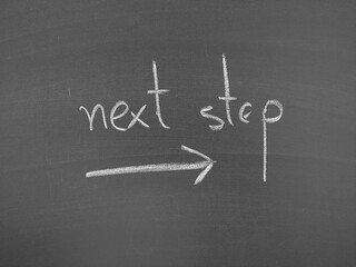 Obraz premium next step written in chalk on a blackboard with an arrow pointing to the right