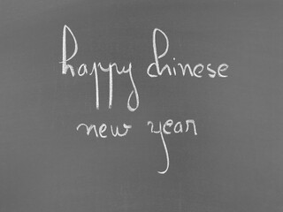 Obraz premium Happy chinese new year written in chalk on a blackboard surface
