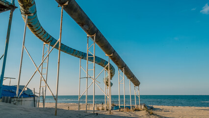 abandoned rusty water attraction on the autumn beach on the Azov Sea coast