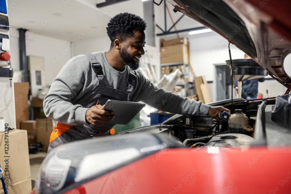 Poster smiling multicultural automotive technician pouring car oil at car service center and using tablet f