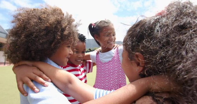 Children in school hugging and smiling together, enjoying outdoor activity